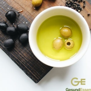 Schwarze und grüne Oliven in Olivenöl